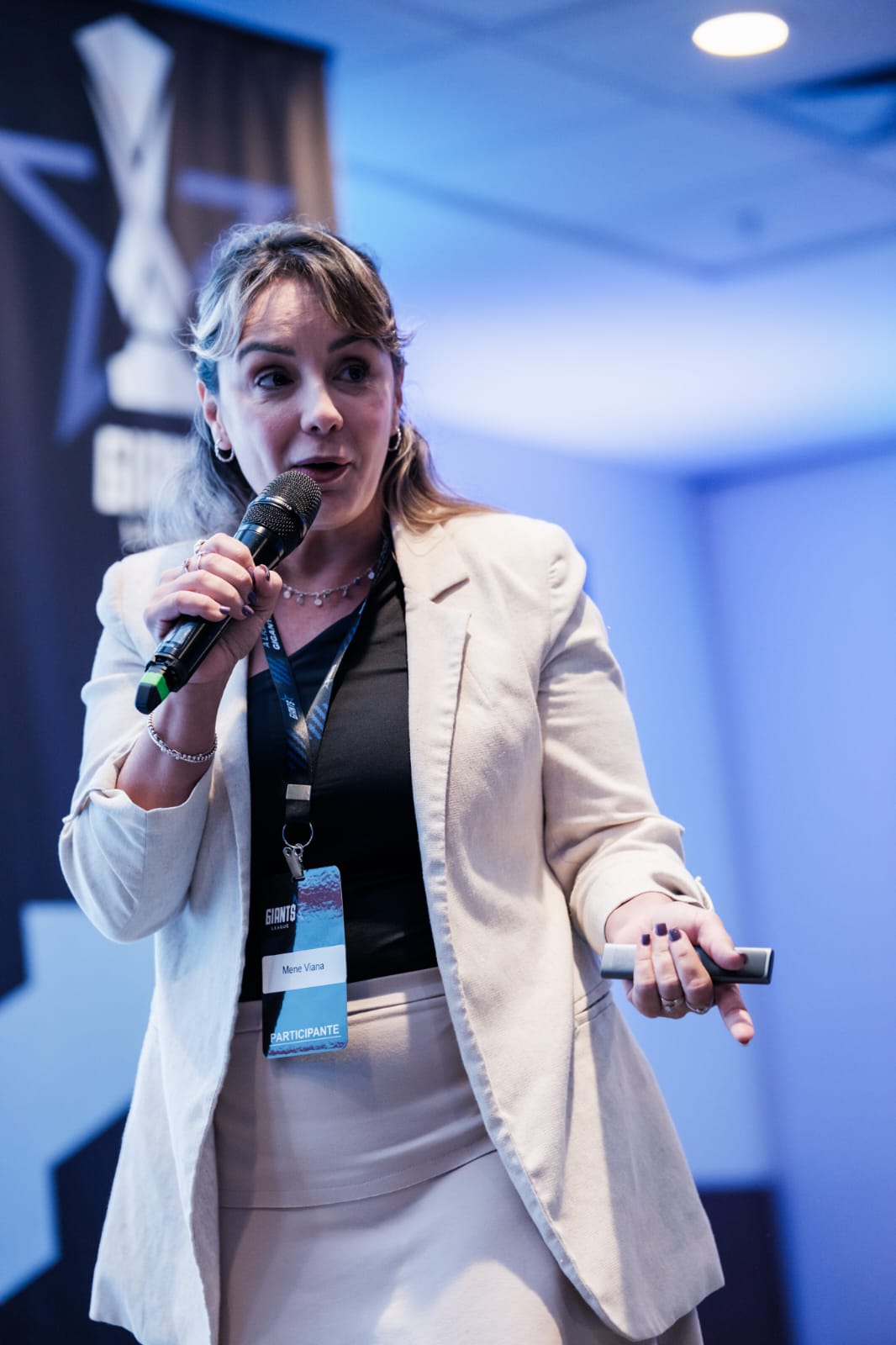 Mene Vianna palestrando com microfone no palco do Giants League
